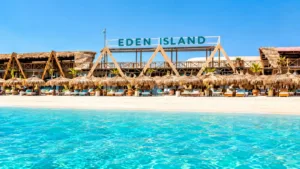 Остров Эден в Хургаде: что ждёт на экскурсии и отзывы Остров Эден (Eden Island) в Хургаде с моря: пляж с пальмовыми зонтиками и вывеской EDEN ISLAND на острове Большой Гифтун